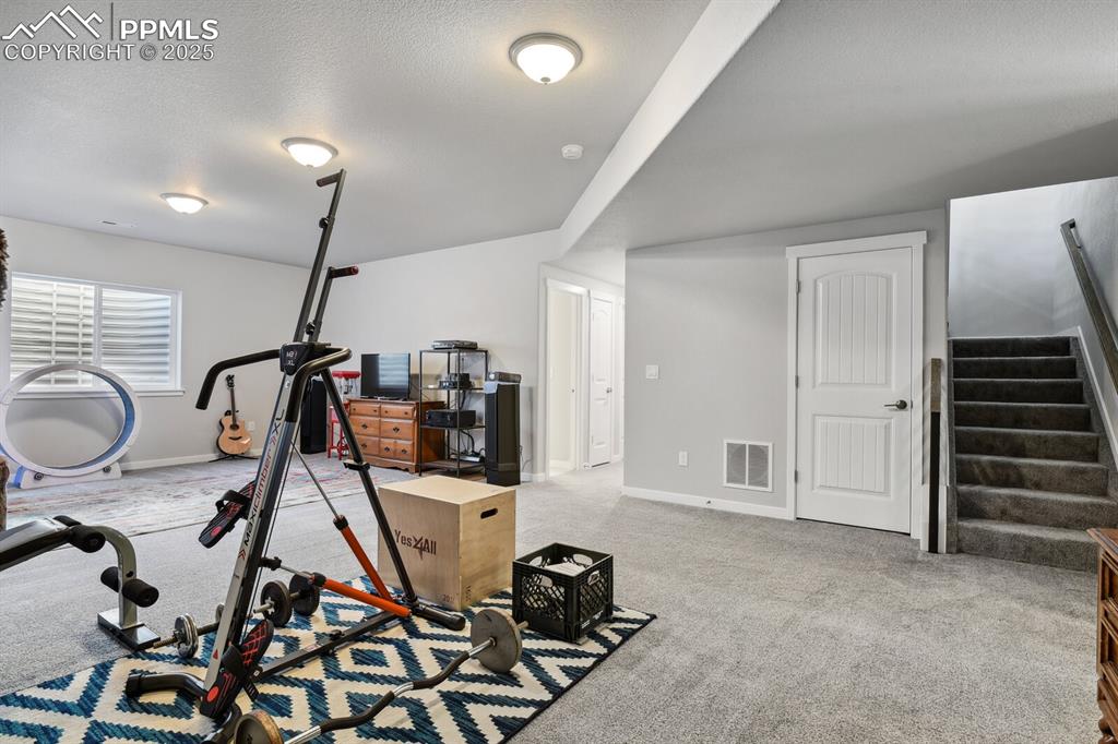 Image 30 of 47: Workout area featuring carpet and baseboards