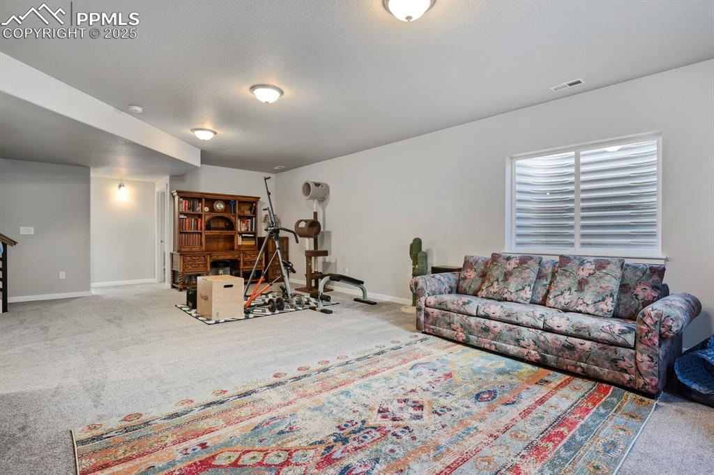 Image 33 of 47: Carpeted living area featuring baseboards