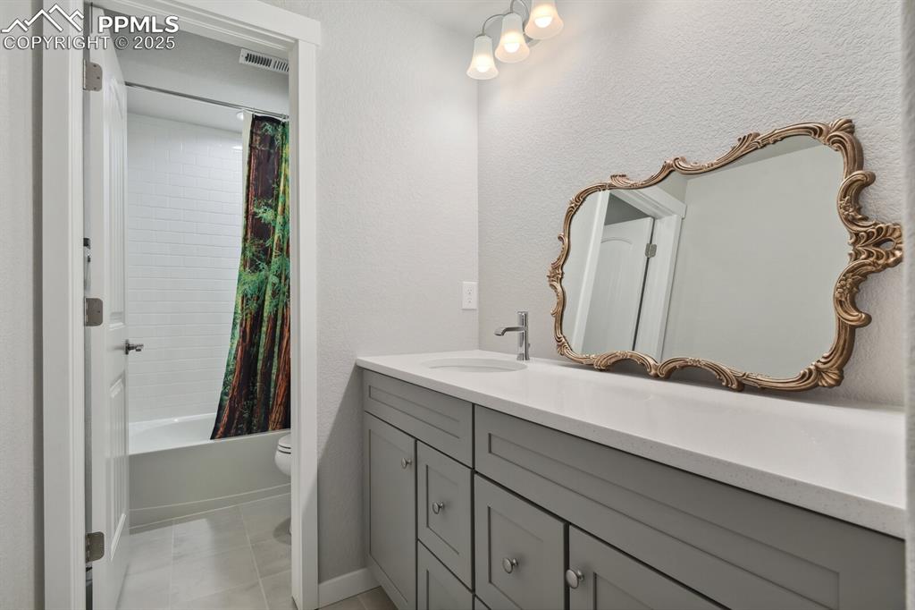 Image 35 of 47: Full bathroom featuring vanity and shower / bathtub combination with curtai