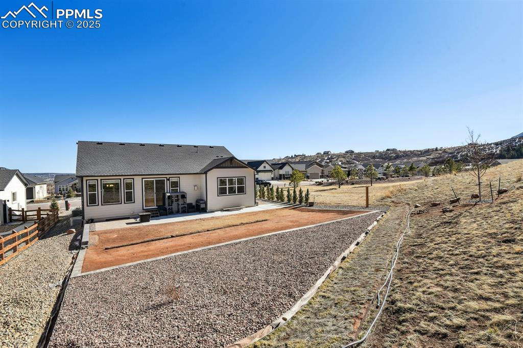 Image 43 of 47: Rear view of house with a patio and a shingled roof