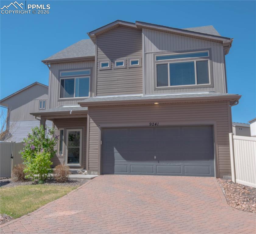 Image 1 of 30: Two-story residence featuring horizontal siding and vertical paneling accen