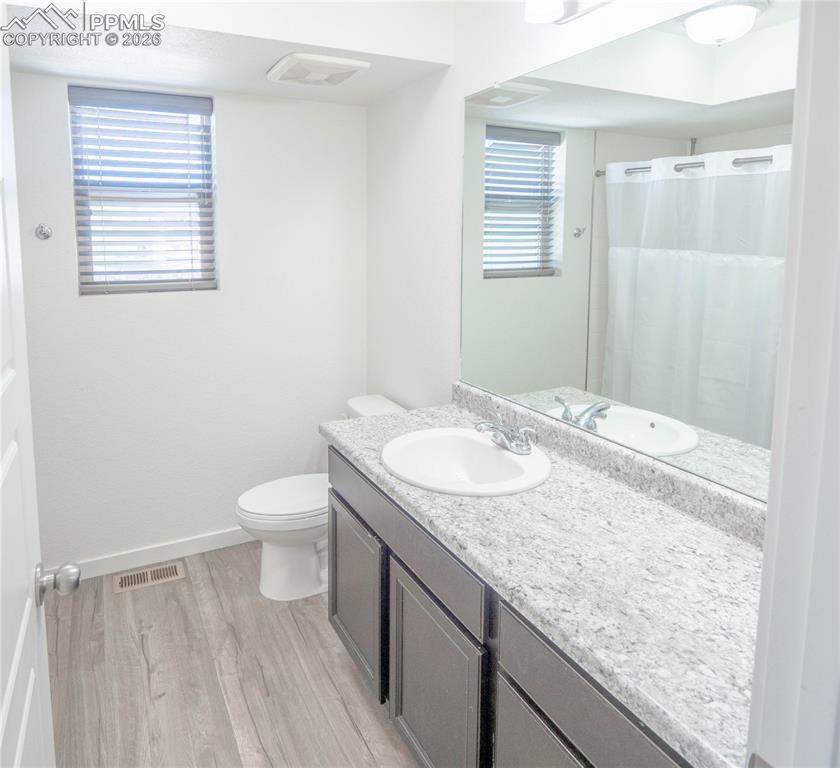 Image 15 of 30: Bathroom featuring a dark wood-finish vanity with an integrated sink, a spe