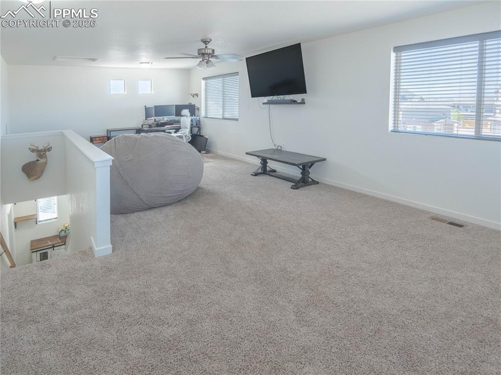 Image 19 of 30: Spacious upper-level room featuring light neutral carpeting, white walls, a