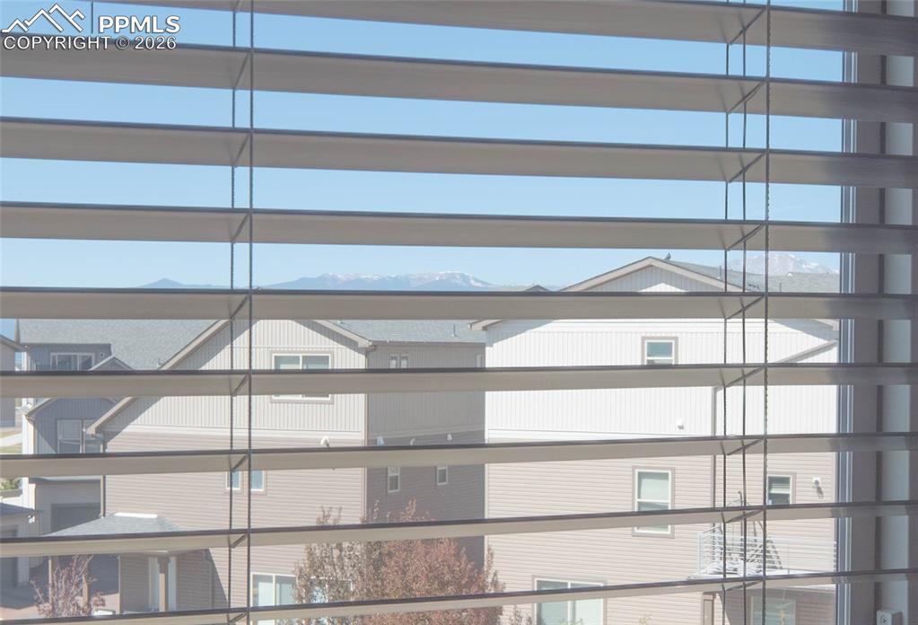 Image 20 of 30: Horizontal window blinds with a distant mountain range backdrop