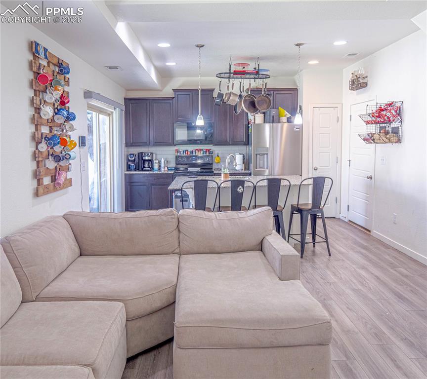 Image 6 of 30: Open-concept living area featuring wood-finish flooring, recessed lighting,