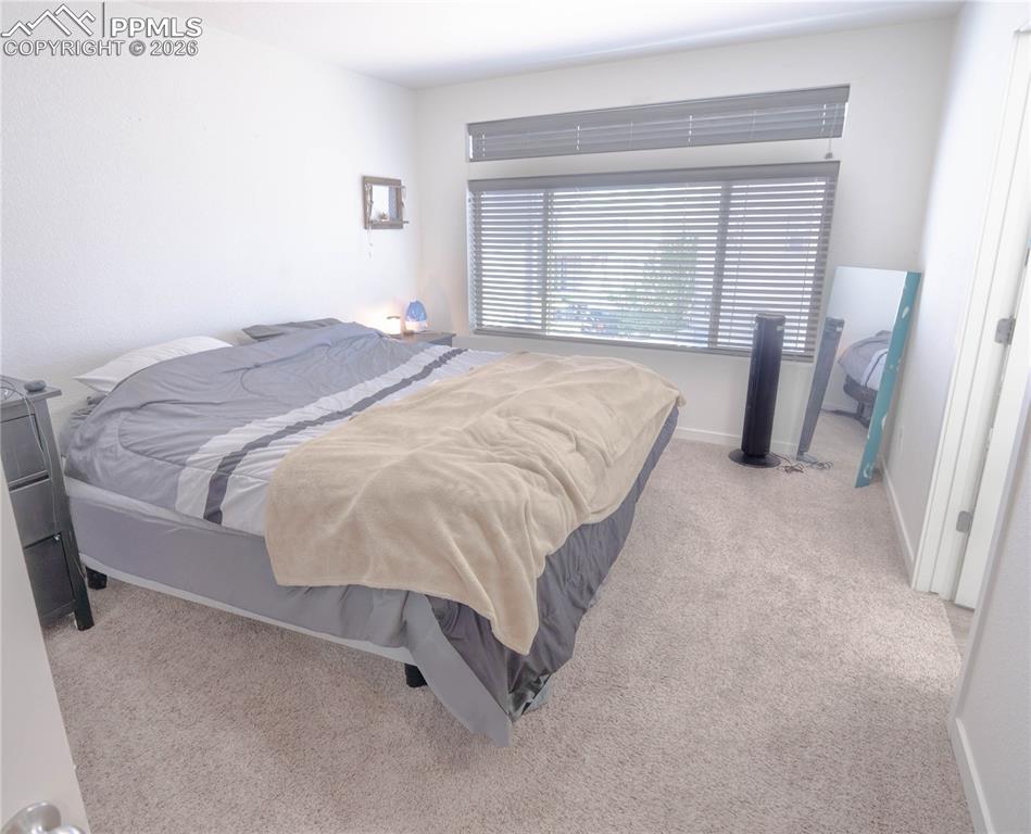 Image 8 of 30: Carpeted room featuring a large window with horizontal blinds and an upper 