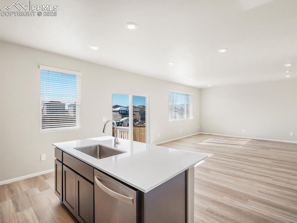 Image 12 of 27: Kitchen with light wood-style floors, dishwasher, open floor plan, recessed