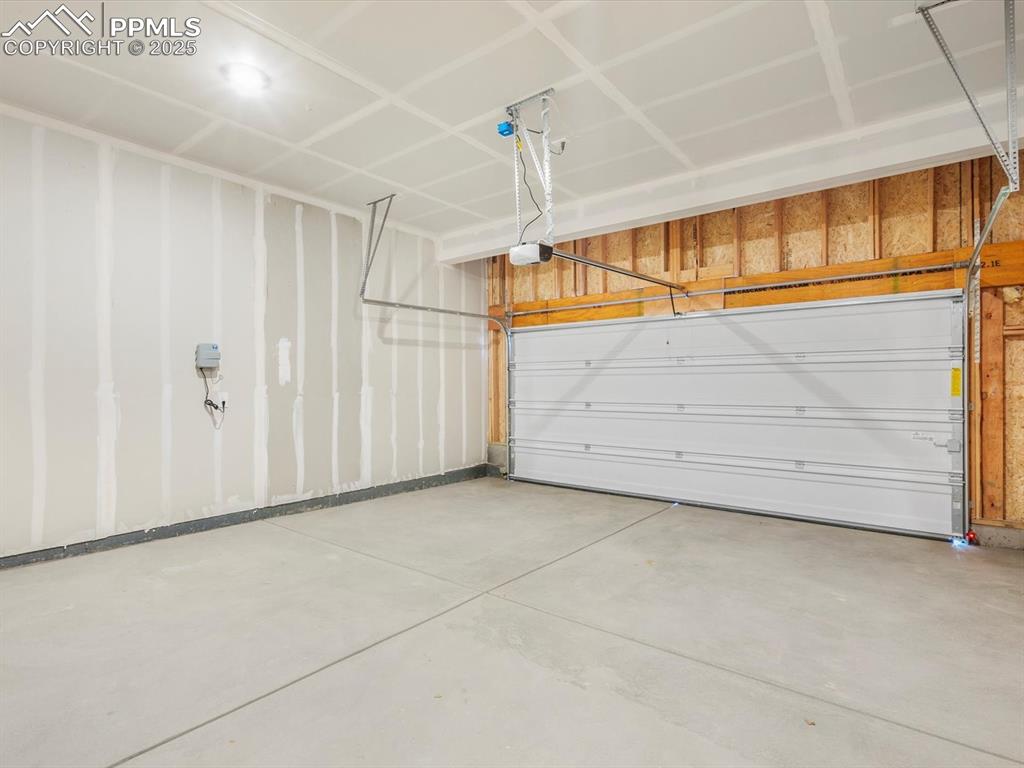Image 13 of 27: Garage featuring a garage door opener