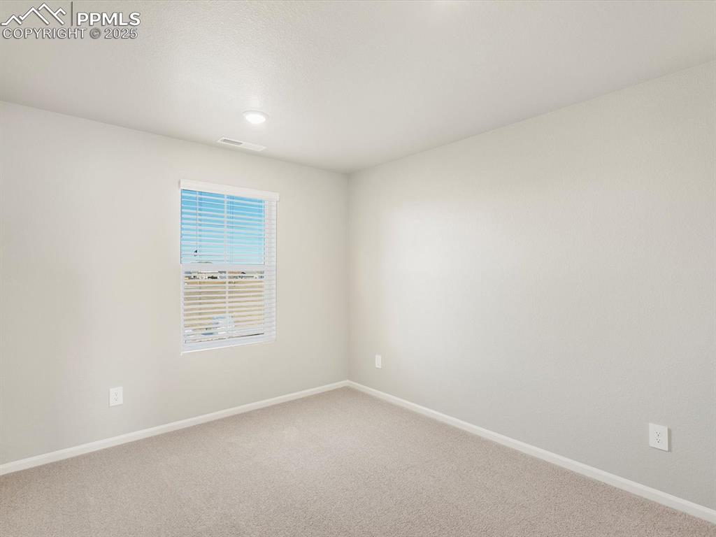 Image 23 of 27: Spare room featuring baseboards and carpet floors