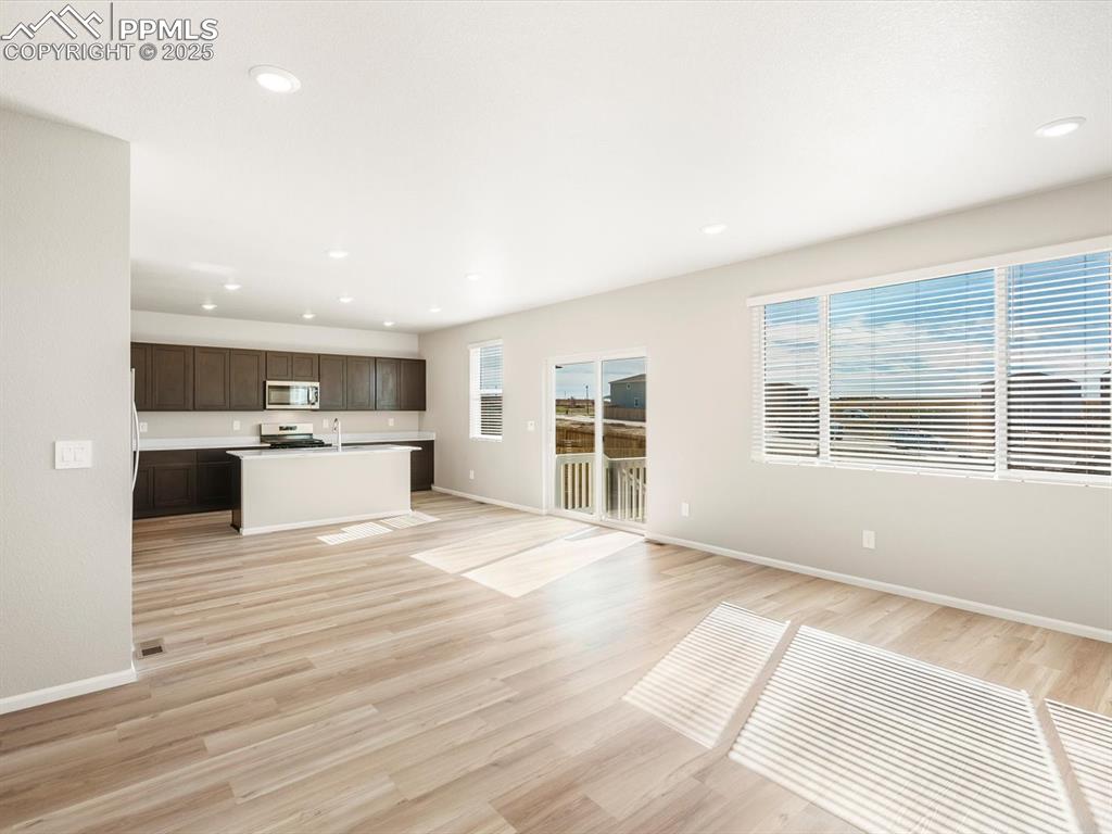 Image 5 of 27: Unfurnished living room with light wood-style flooring and recessed lightin