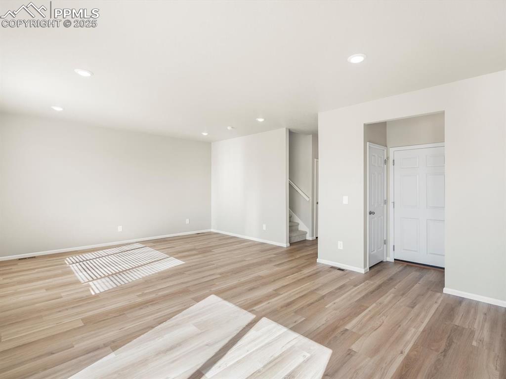 Image 6 of 27: Empty room with recessed lighting, light wood finished floors, and stairway