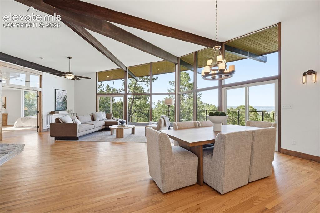Image 13 of 48: Vaulted ceiling with exposed wood beams, expansive floor-to-ceiling windows