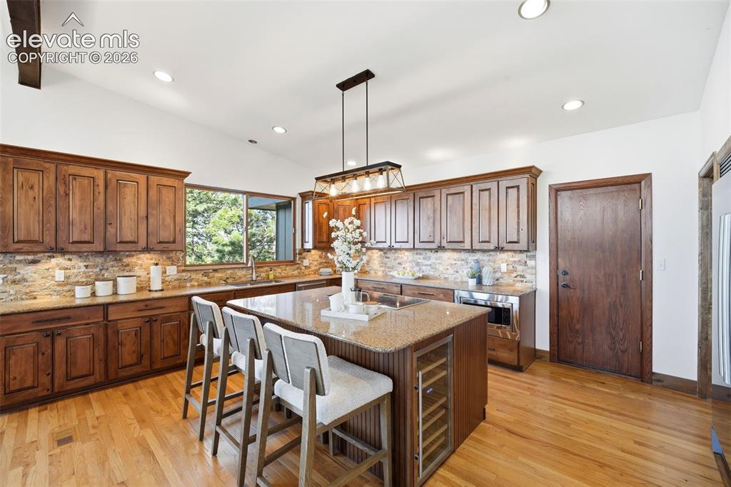 Image 14 of 48: Spacious kitchen featuring a large central island with seating, a built-in 