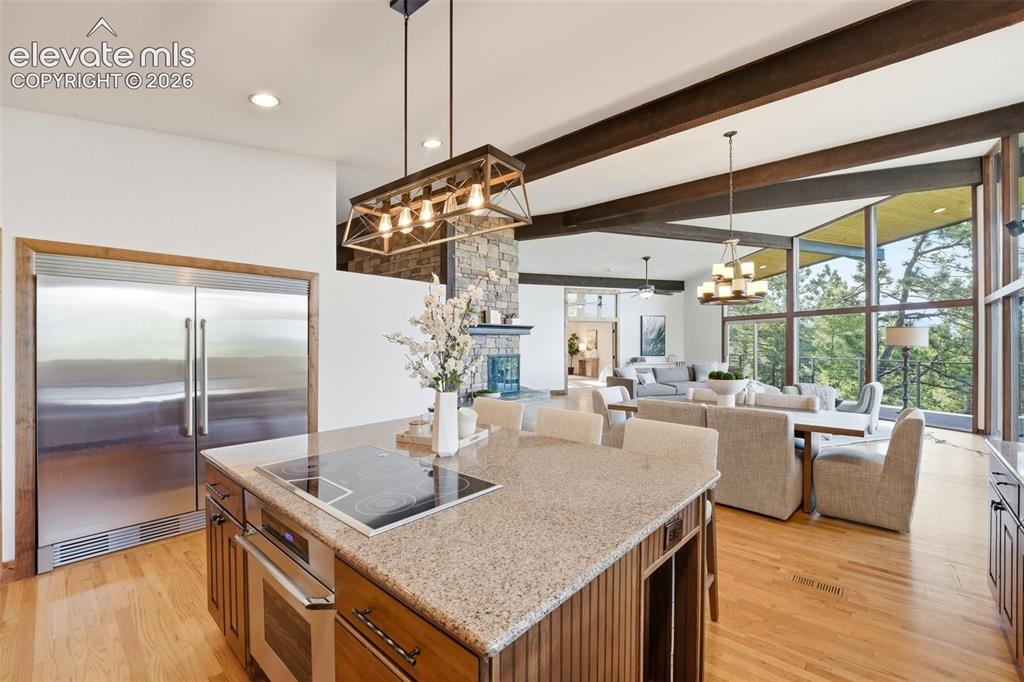 Image 16 of 48: Kitchen island with integrated cooktop and oven, granite-finish countertop,