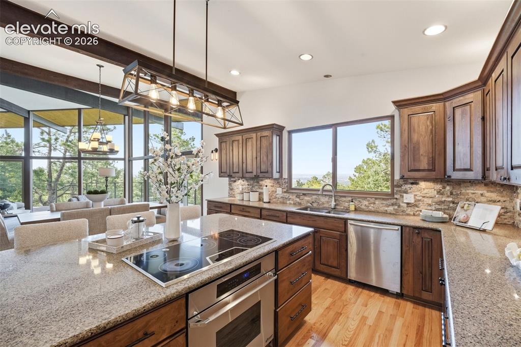 Image 17 of 48: Kitchen featuring a large central island with integrated cooktop and oven, 