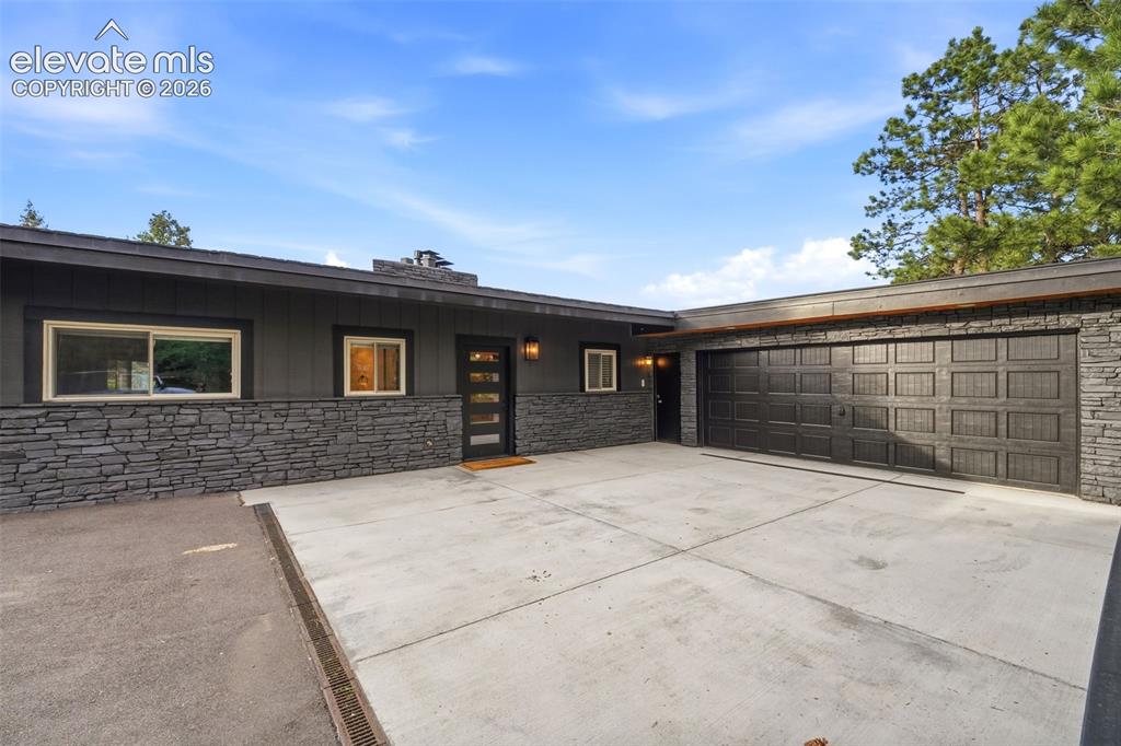 Image 2 of 48: Contemporary exterior with dark siding and stacked stone accents