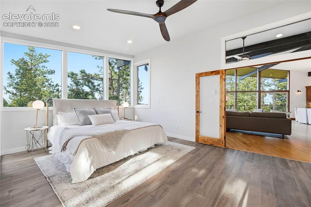 Image 23 of 48: Expansive windows offering treetop scenery, wood-finish flooring, recessed 