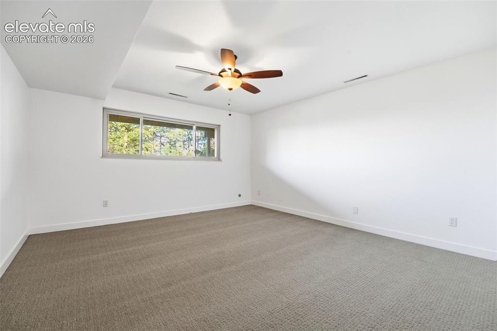 Image 36 of 48: Spacious room featuring neutral carpeting, a large horizontal window, white