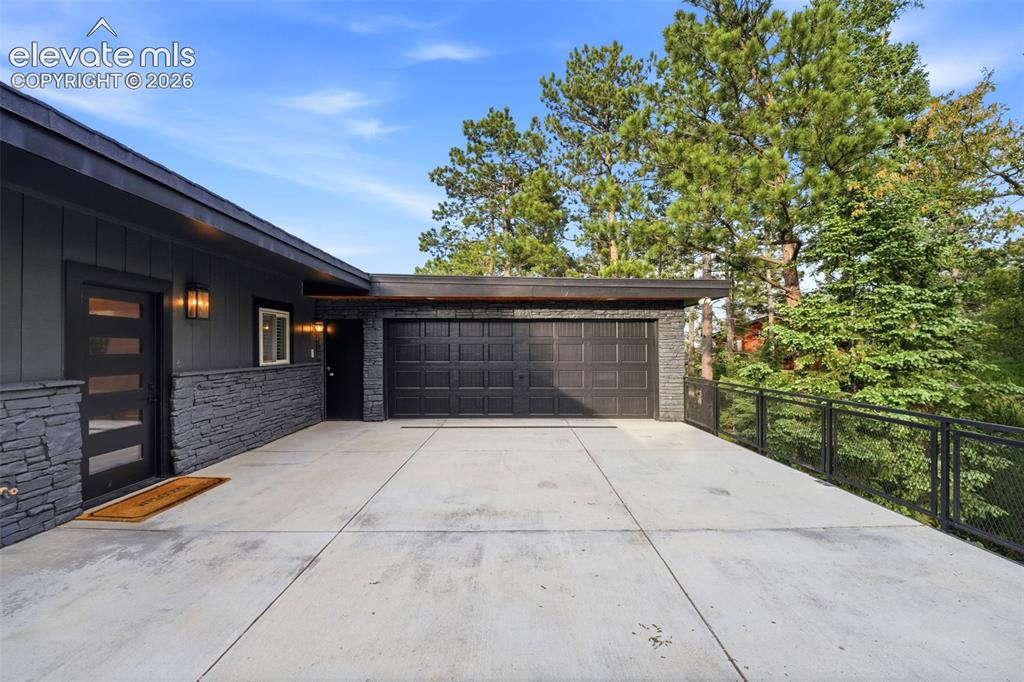 Image 45 of 48: Contemporary exterior featuring dark horizontal siding and stone veneer acc