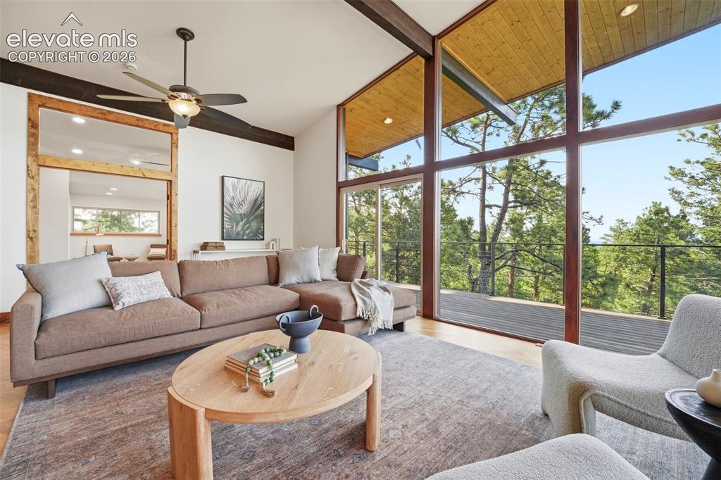 Image 8 of 48: Expansive window wall with a sliding glass door opening to an outdoor deck