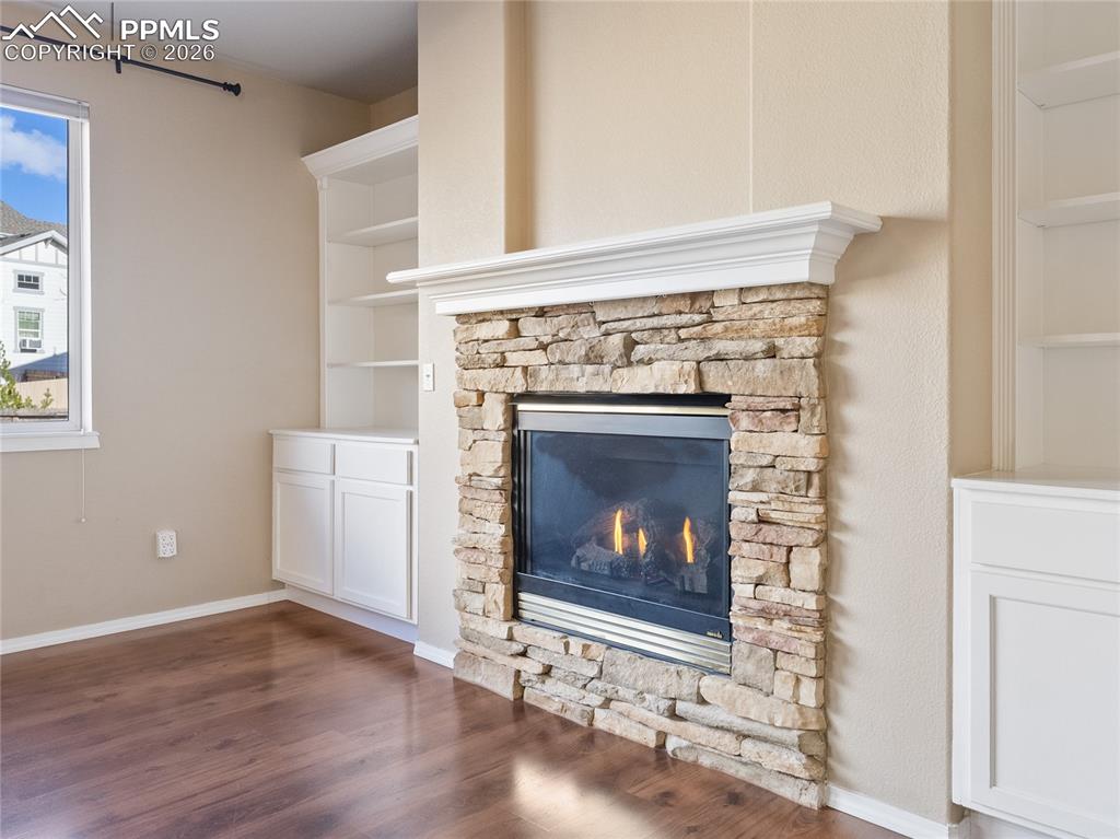 Image 11 of 46: Detailed view of built in features, a stone fireplace, and wood finished fl