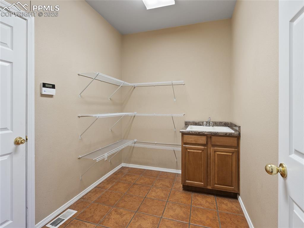 Image 16 of 46: Pantry/mud room with a sink and dark tile patterned flooring