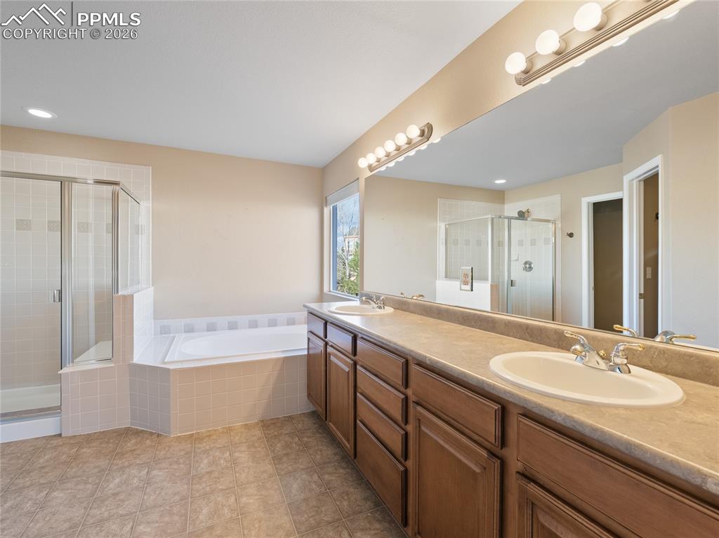 Image 23 of 46: Bathroom featuring a shower stall, double vanity, a garden tub, and recesse