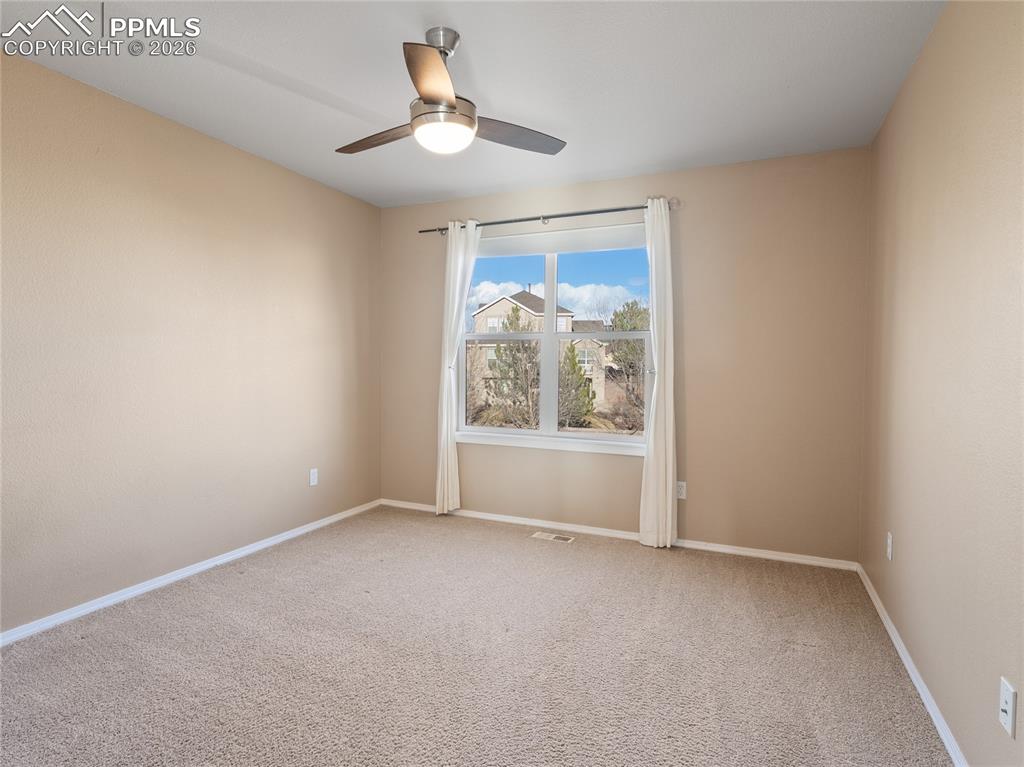Image 30 of 46: Upper level bedroom featuring carpet floors and a ceiling fan