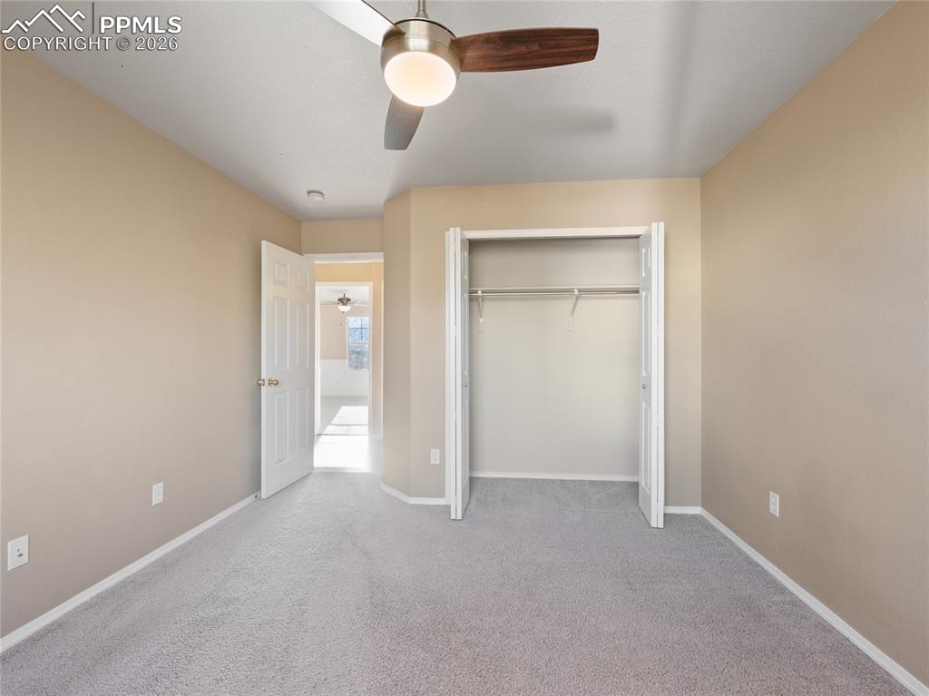 Image 31 of 46: Unfurnished bedroom with a ceiling fan, light colored carpet, and a closet
