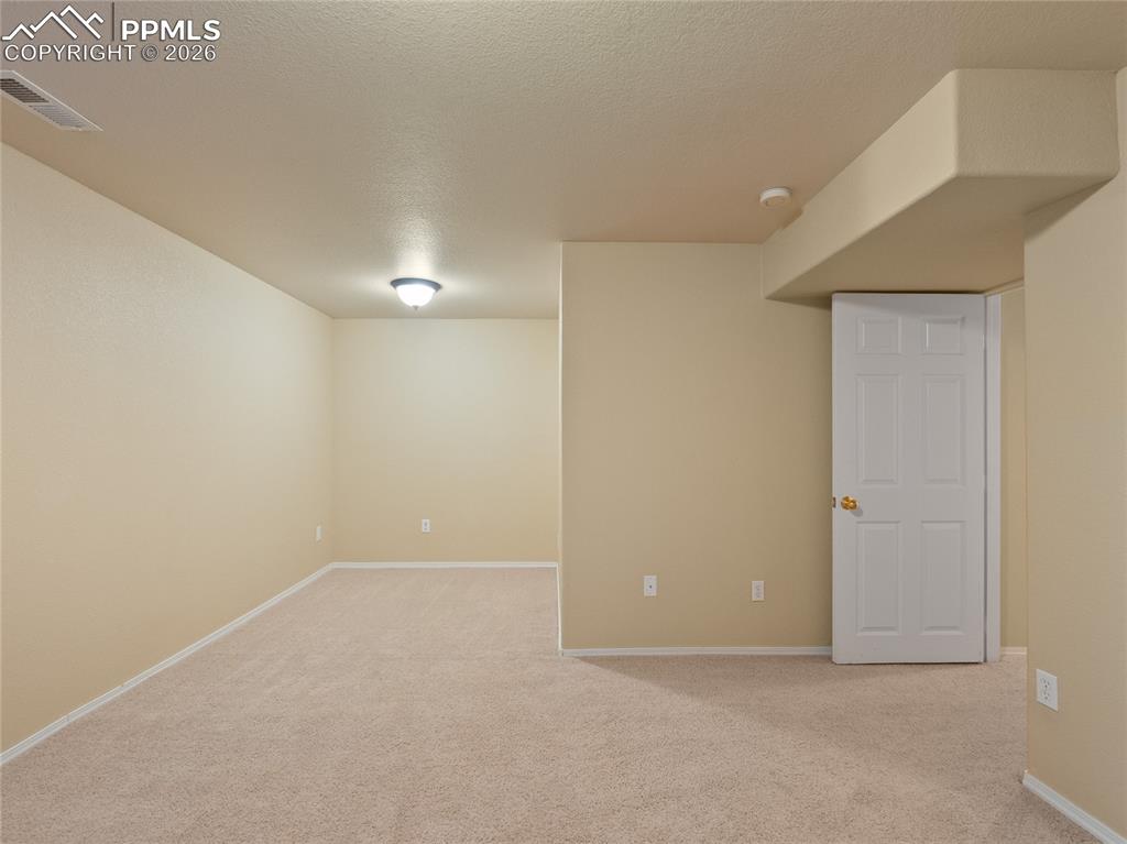 Image 41 of 46: Finished basement bedroom featuring light colored carpet and a textured ce