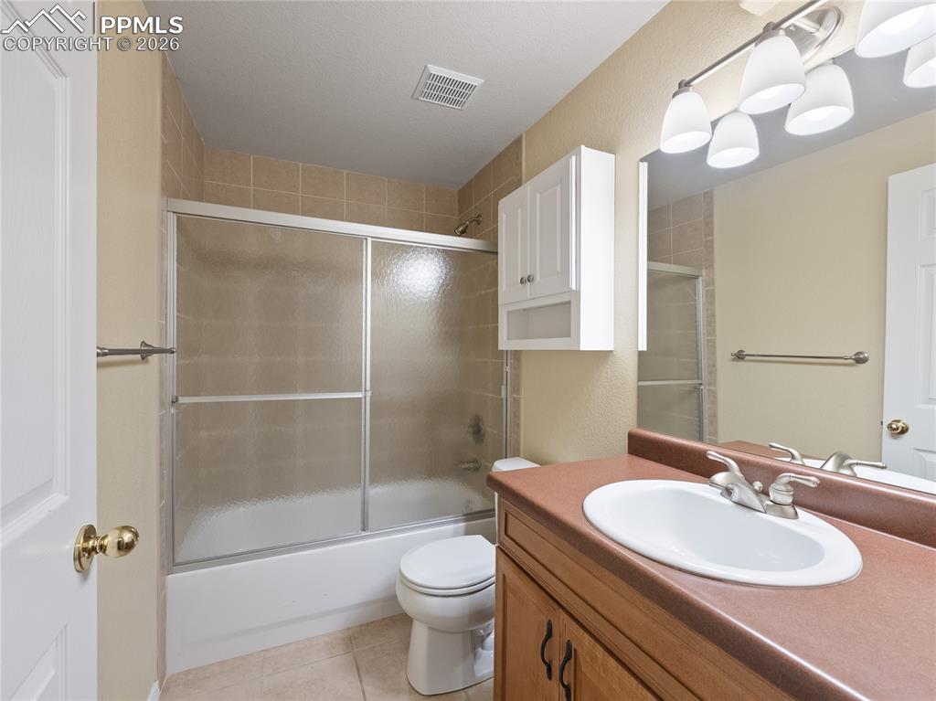 Image 42 of 46: Full bathroom in basement featuring vanity, enclosed tub / shower combo, an