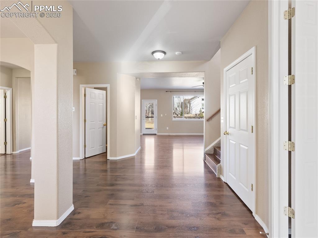 Image 9 of 46: Entryway with dark wood-type flooring and arched walkways
