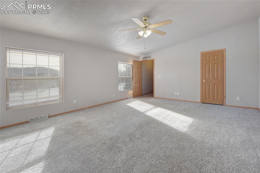 Image 20 of 50: Master bedroom with ceiling fan