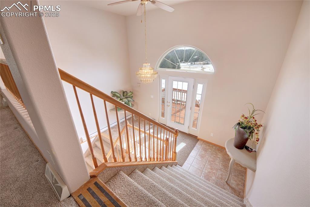 Image 30 of 50: Foyer with ceiling fan with notable chandelier