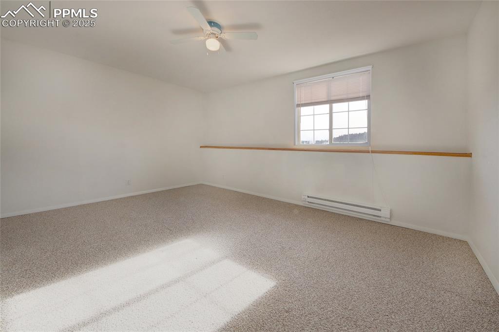 Image 39 of 50: Bedroom 5 in basement with window ledge and ceiling fan