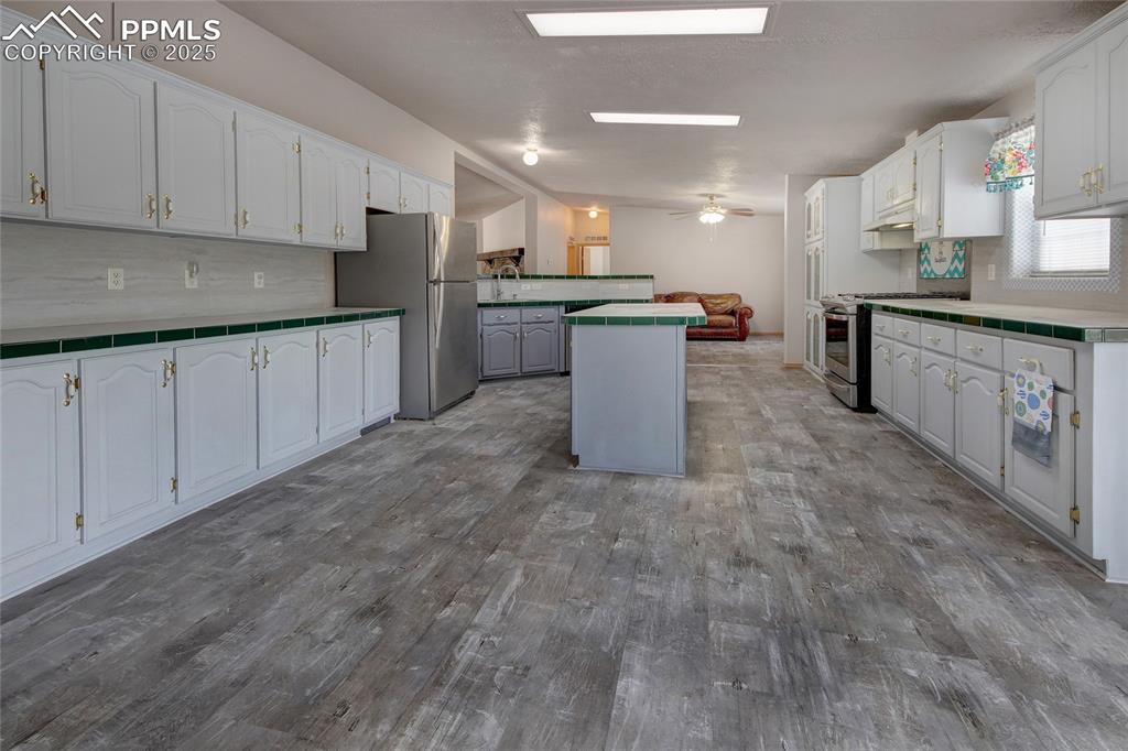 Image 6 of 50: Kitchen featuring lvt floors, spaciousness, and island