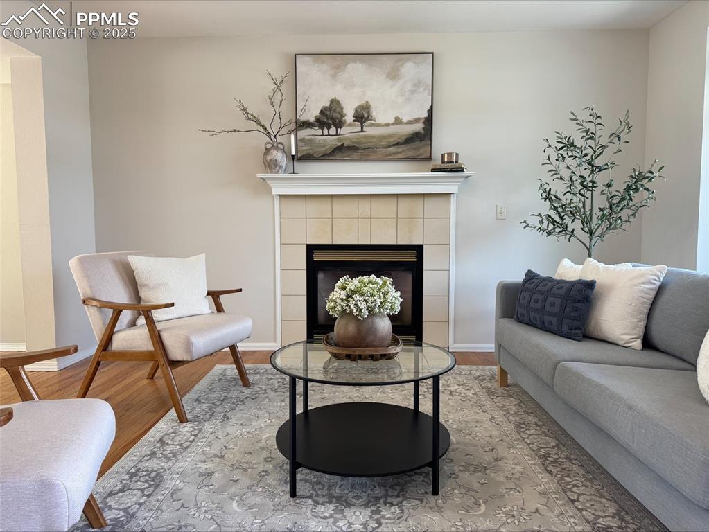 Image 16 of 45: Living room w/ oak floors and a tiled fireplace