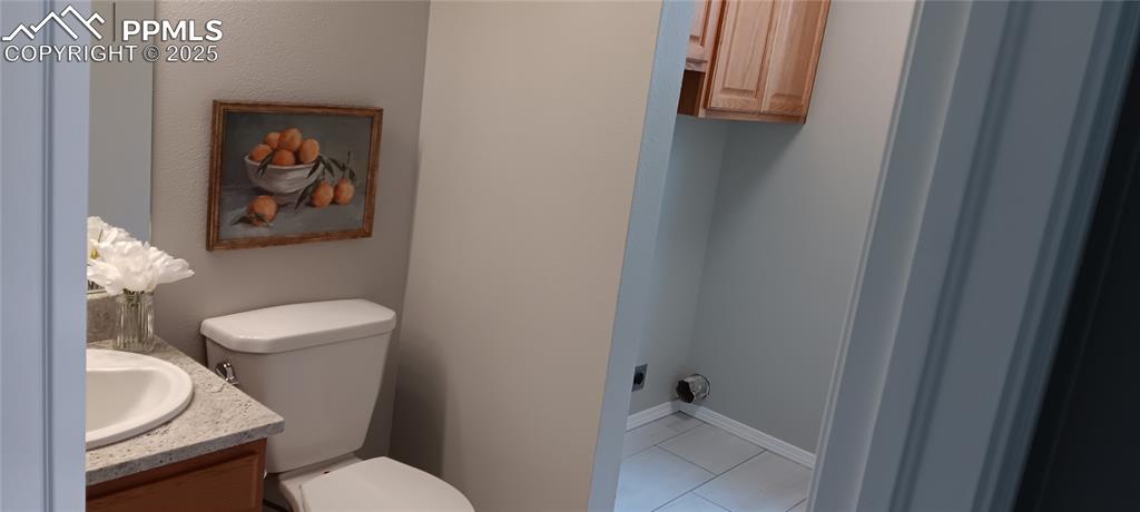 Image 32 of 45: Half bathroom / laundry with pantry storage cabinets on main level. No goin