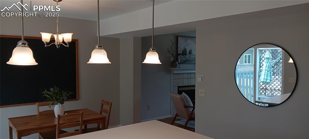 Image 34 of 45: Dining area featuring a chandelier and a fireplace