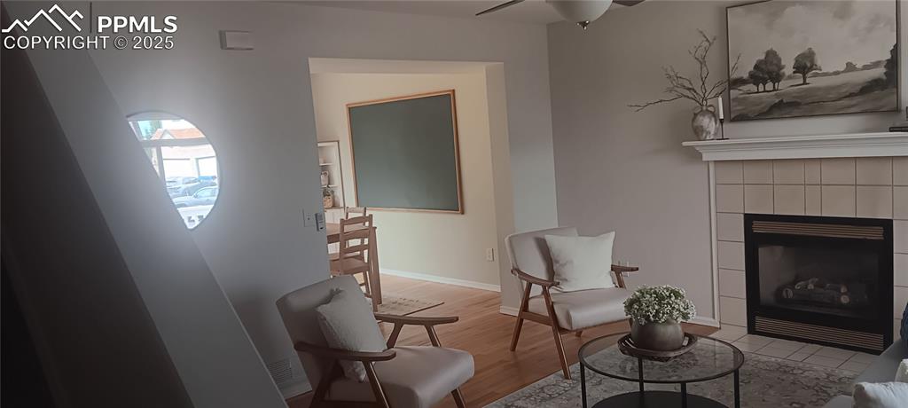Image 41 of 45: Living area with a fireplace, Oak flooring, and ceiling fan