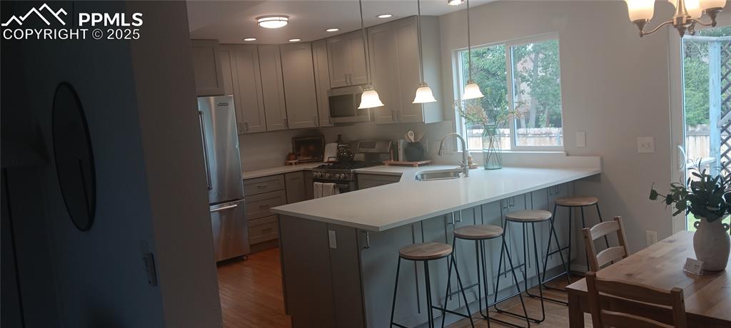 Image 42 of 45: Kitchen with a peninsula, appliances with stainless steel finishes, a kitch