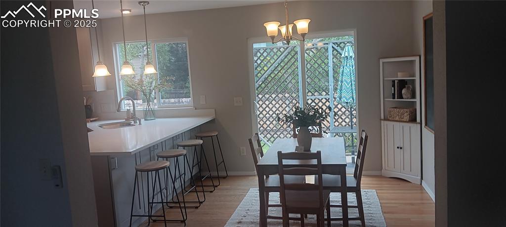 Image 43 of 45: Dining room featuring a chandelier, plenty of natural light, and oak floors