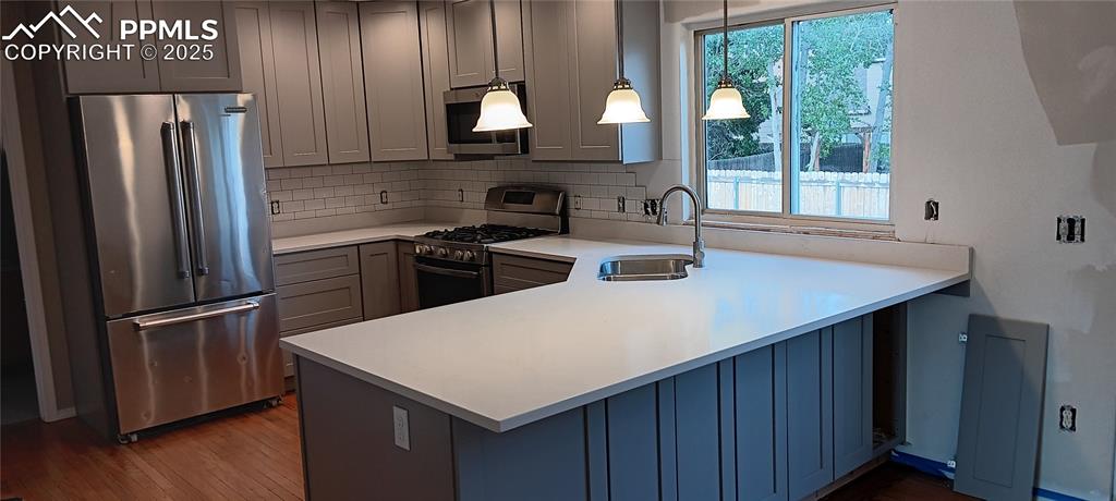 Image 5 of 45: Kitchen featuring appliances with stainless steel finishes, a peninsula, de