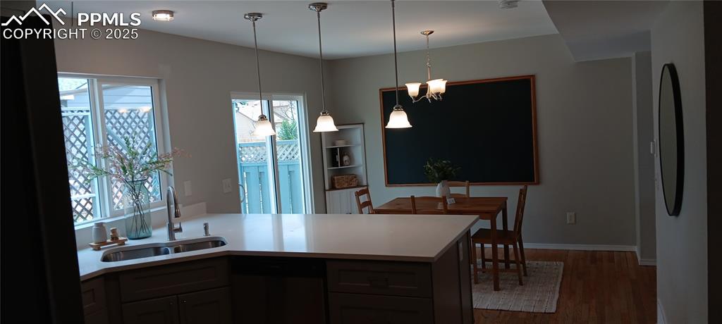Image 6 of 45: Kitchen with dishwasher, oak floors, light countertops, a peninsula, recess