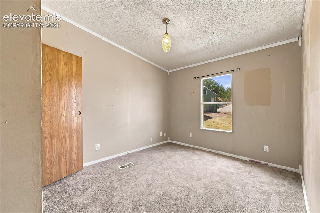 Image 13 of 19: Neutral-toned walls complement the textured ceiling