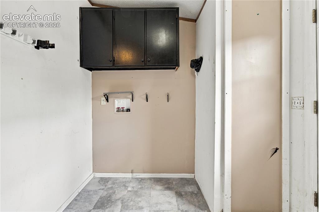 Image 16 of 19: Utility area featuring overhead cabinetry, wall-mounted storage, and a dura