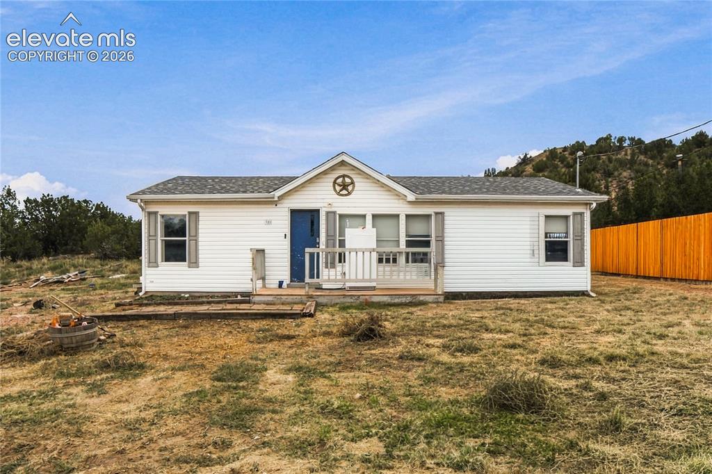 Image 2 of 19: White siding exterior with a dark blue front door, covered porch, and a gab