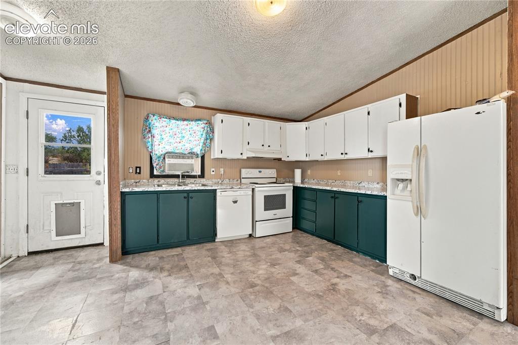 Image 5 of 19: Kitchen featuring L-shaped cabinetry with white upper and teal lower cabine