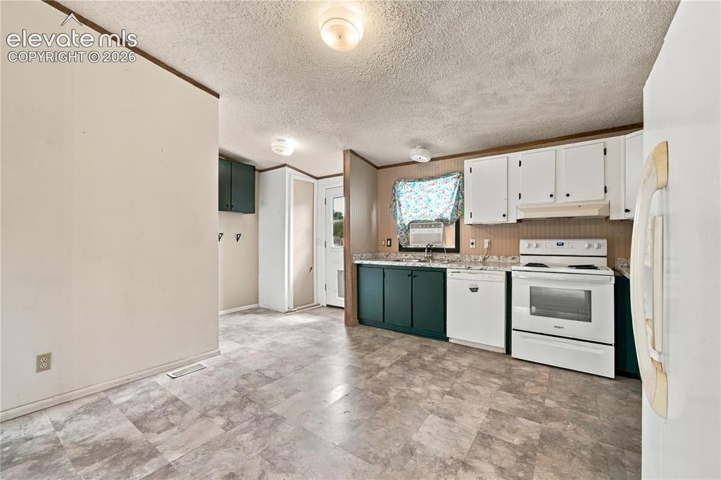 Image 7 of 19: Kitchen featuring white upper cabinetry, dark lower cabinetry, a white elec