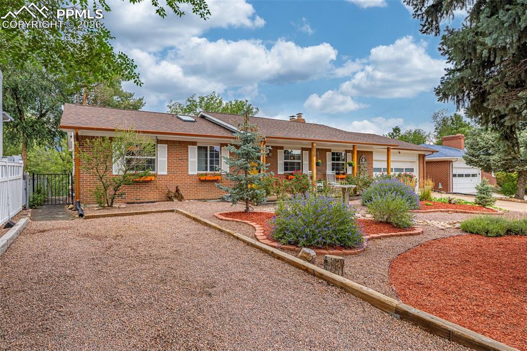 Image 2 of 44: View of front of home featuring a chimney, brick siding, and roof with shin